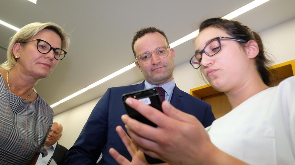 Jens Spahn schaut mit der sächsischen Sozialministerin Barbara Klepsch auf eine Klinik-App in Zwickau