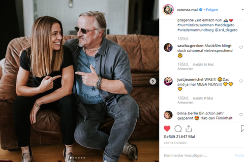 Vanessa Mai sitzt neben Axel Prahl auf einer Couch.
