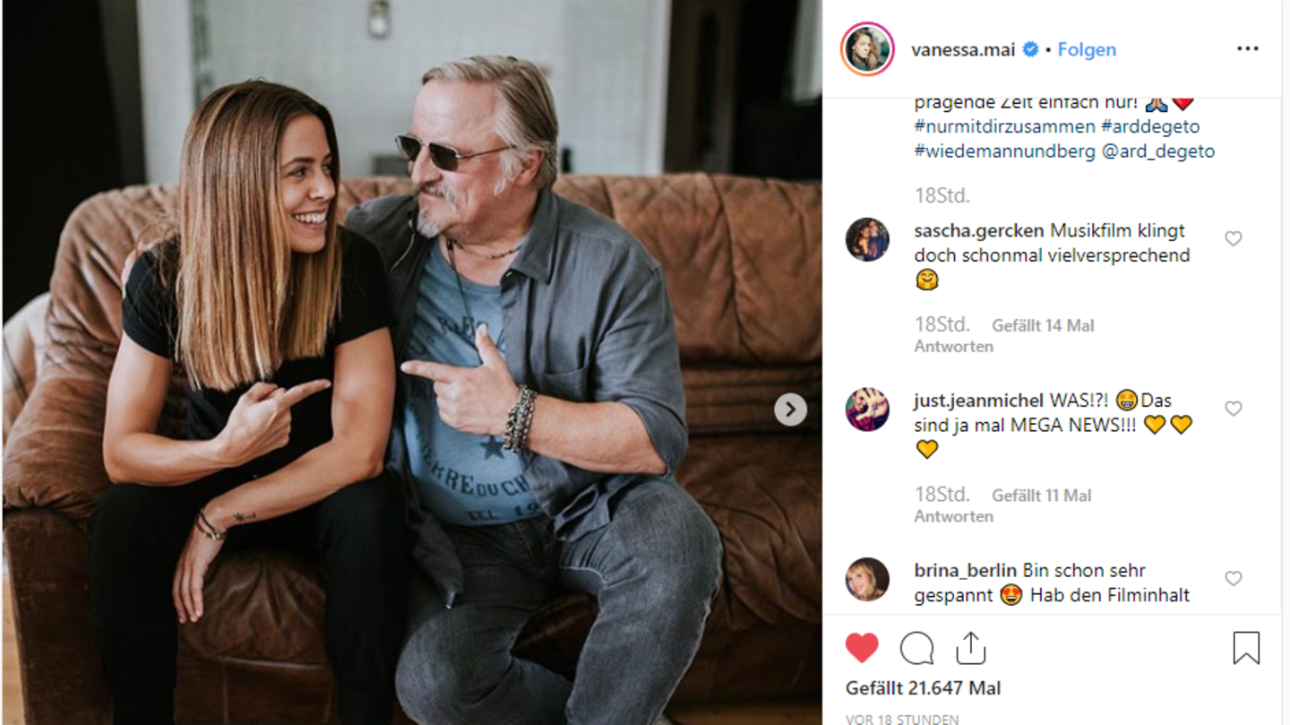 Vanessa Mai sitzt neben Axel Prahl auf einer Couch.