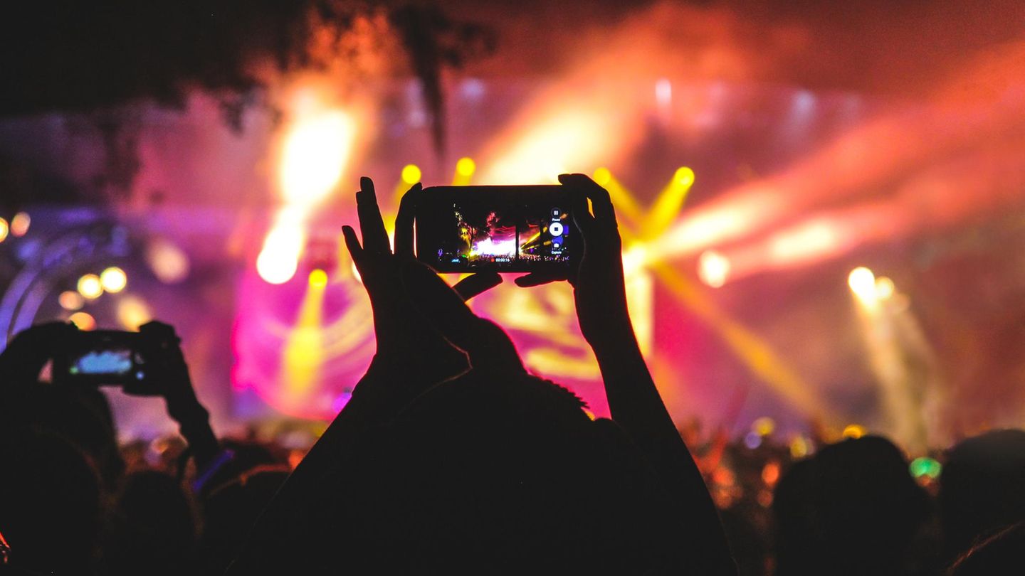 Konzertbesucher machen Fotos mit dem Smartphone