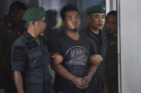 Polizisten führen den Mörder der deutschen Touristin in Handschellen ab