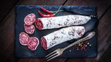 Edelschimmel auf Salami kann unbedenklich verzehrt werden. Er verleiht dem Produkt einen würzigen Geschmack, konserviert und schützt vor Besiedelung mit gefährlichem Schimmel. 