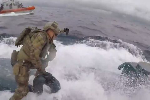 Die Männer der Küstenwache riskieren einen waghalsigen Sprung auf das mit hoher Geschwindigkeit fortfahrende Schiff.