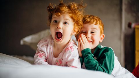 Zwei rothaarige Kinder im Bett