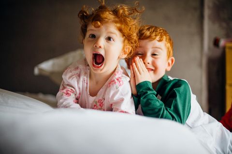 Zwei rothaarige Kinder im Bett
