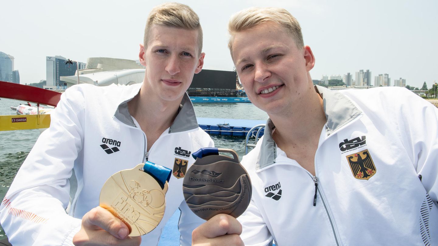 Stolz zeigen Florian Wellbrock (links, Gold) und sein Kumpel Muffels (Bronze) ihre Medaillen ,