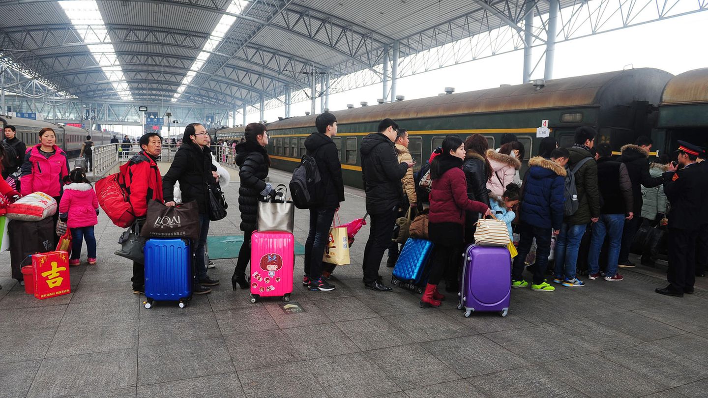 Chinesen stehen Schlage, um einen Zug zu besteigen