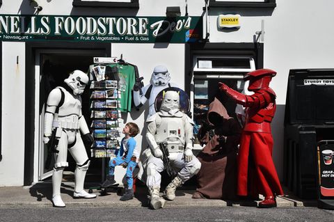 Science Fiction Figuren und ein kleiner Junge vor einem Supermarkt