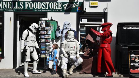 Science Fiction Figuren und ein kleiner Junge vor einem Supermarkt