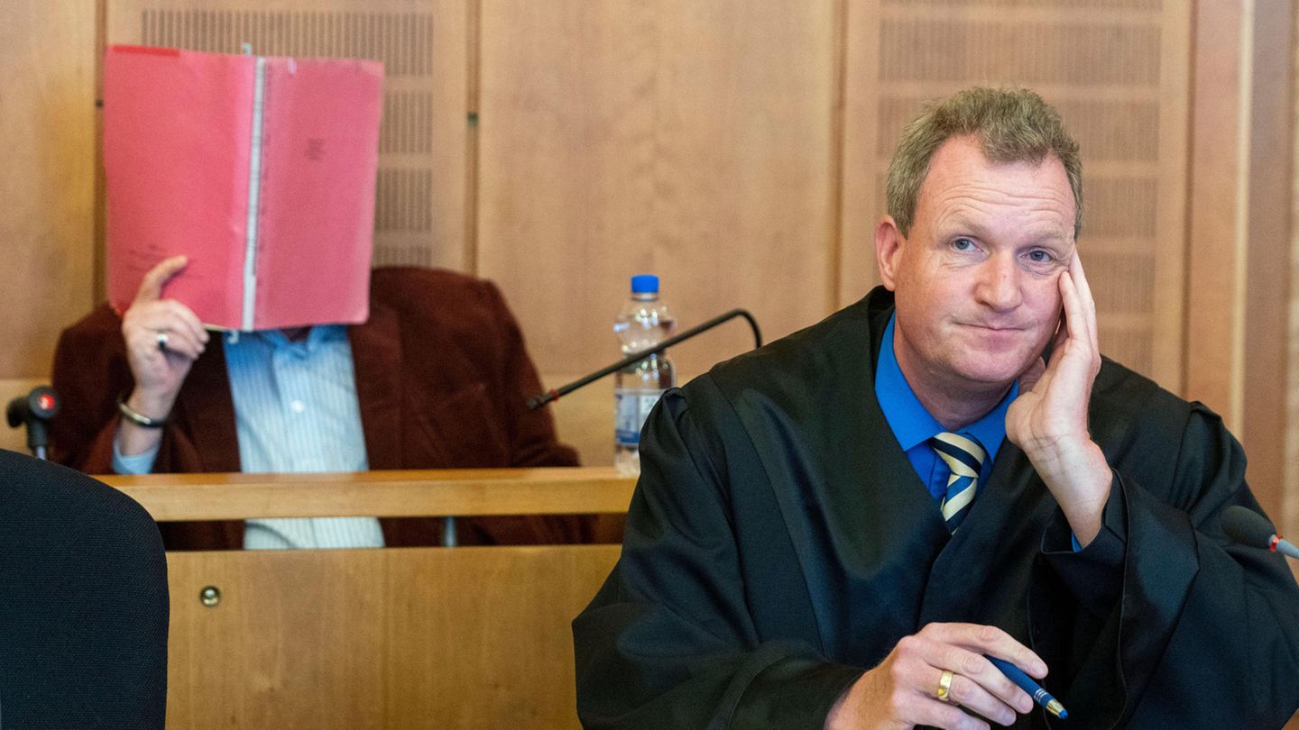 Der Angeklagte (hinten) sitzt mit Rechtsanwalt Philipp Berndtsen vor Prozessbeginn im Gerichtssaal des Landgerichtes