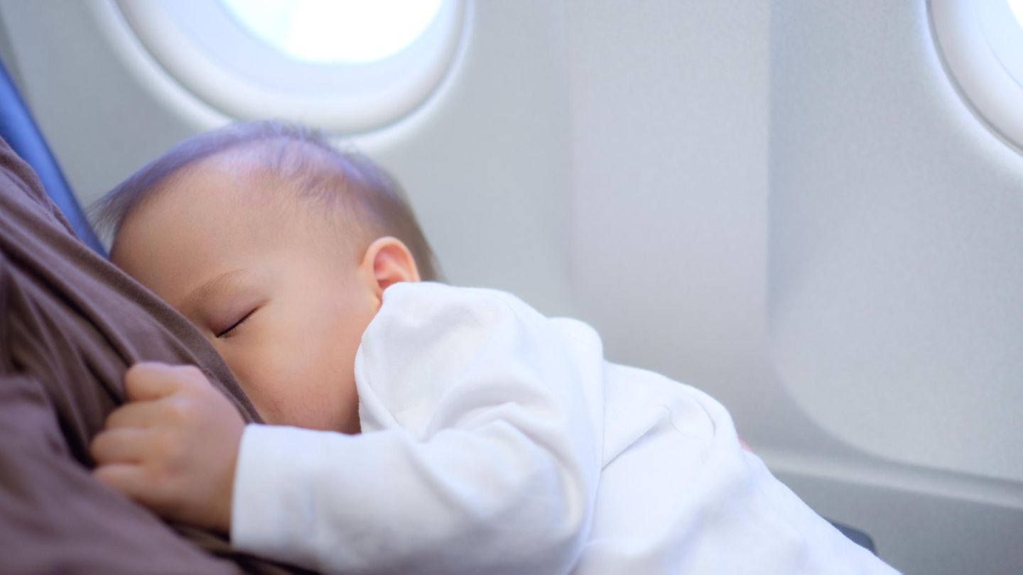 Eine Mutter stillt ihr Baby im Flugzeug
