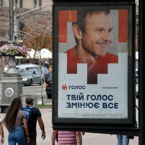 In Kiev gehen Menschen an einem Wahlplakat vorbei