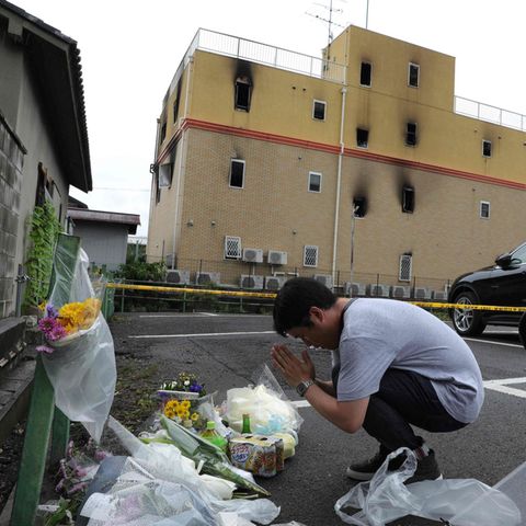 Ein Mann betet vor dem Gebäude, in dem 33 Menschen den Tod fanden