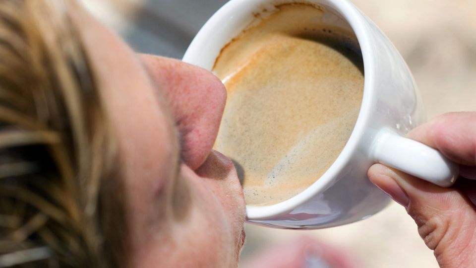 Eine Frau trinkt eine Tasse Kaffee