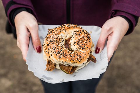 Abnehmen Kalorien: Eine Frau hält einen Bagel in der Hand