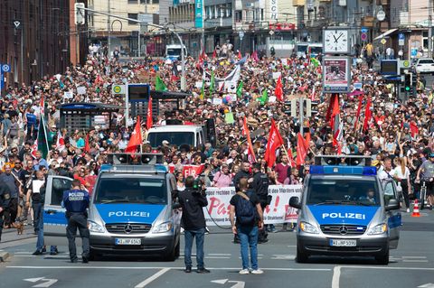 Kassel: Teilnehmer einer Gegendemonstration gehen mit Plakaten und Flaggen durch die Stadt