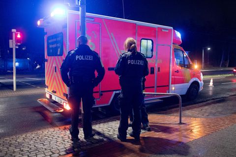 Zwei Polizeibeamte stehen vor einem Rettungswagen (Symbolbild)
