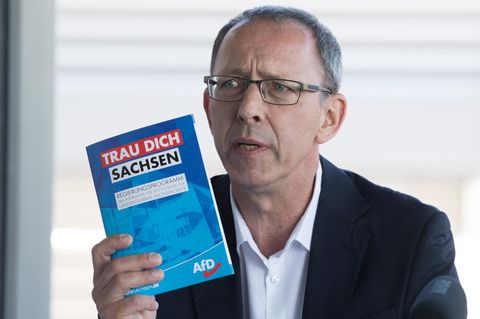 Jörg Urban, Vorsitzender der AfD in Sachsen, hält eine Broschüre mit der Aufschrift "Trau Dich Sachsen"