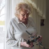 Eine ältere Transfrau mit einem Propellerflugzeug in der Hand