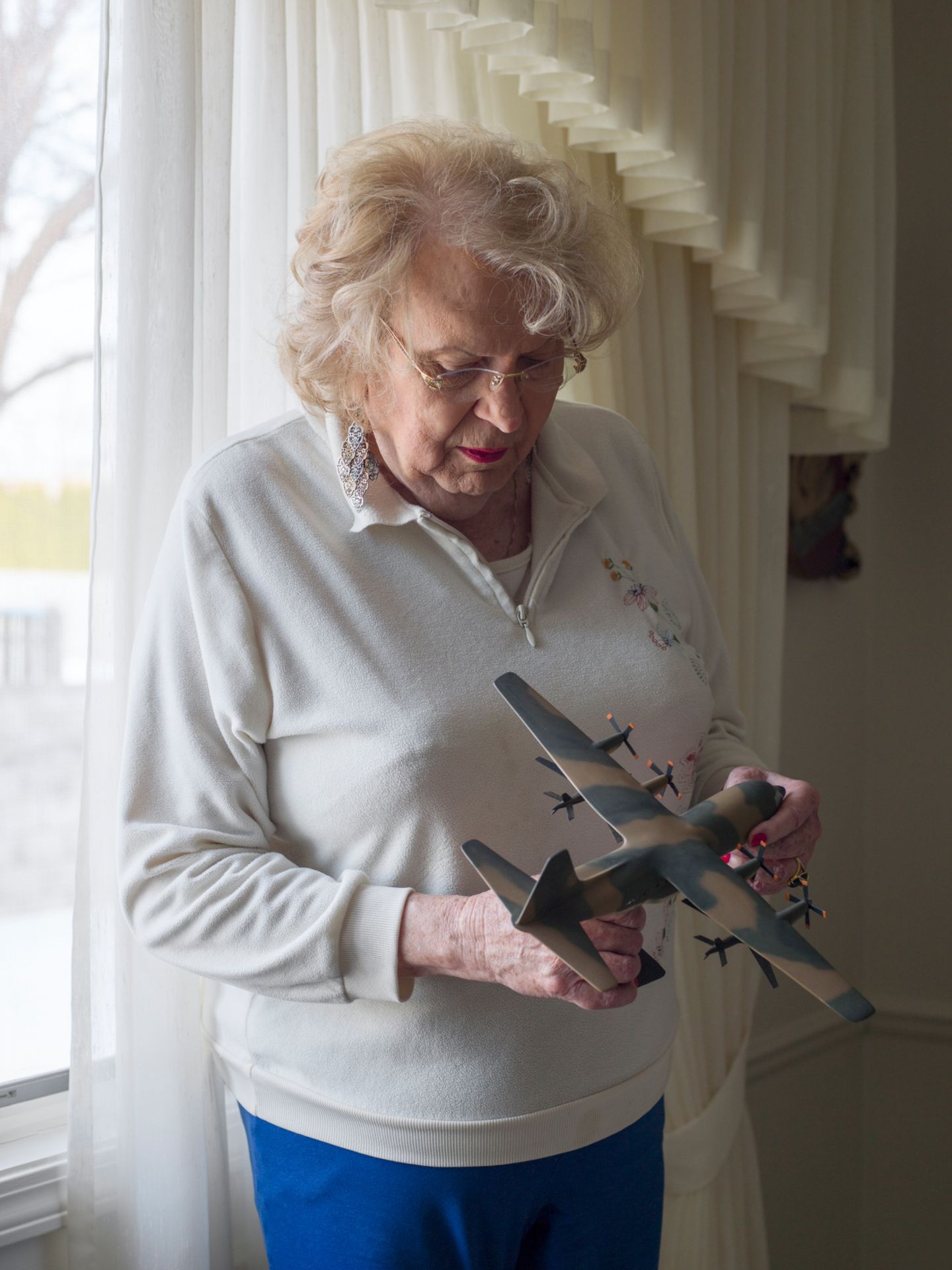 Eine ältere Transfrau mit einem Propellerflugzeug in der Hand