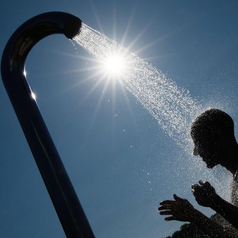 Ein Mann duscht in einem Bielefelder Freibad gegen die Hitze