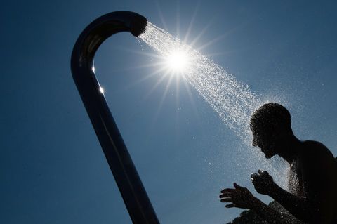 Ein Mann duscht in einem Bielefelder Freibad gegen die Hitze