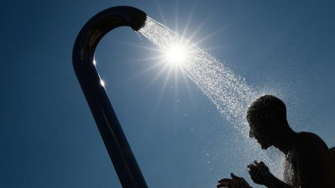 Ein Mann duscht in einem Bielefelder Freibad gegen die Hitze