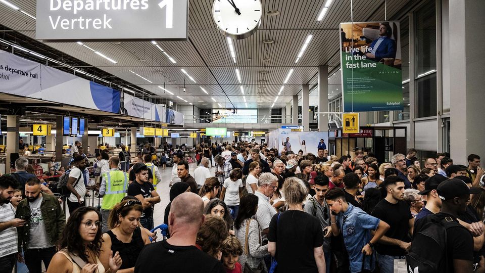 Menschenmassen in der Abflughalle des Flughafens Schiphol.