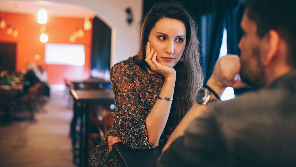 Erstes Date Eine Frau schaut ihr Gegenüber, einen Mann, kritisch an