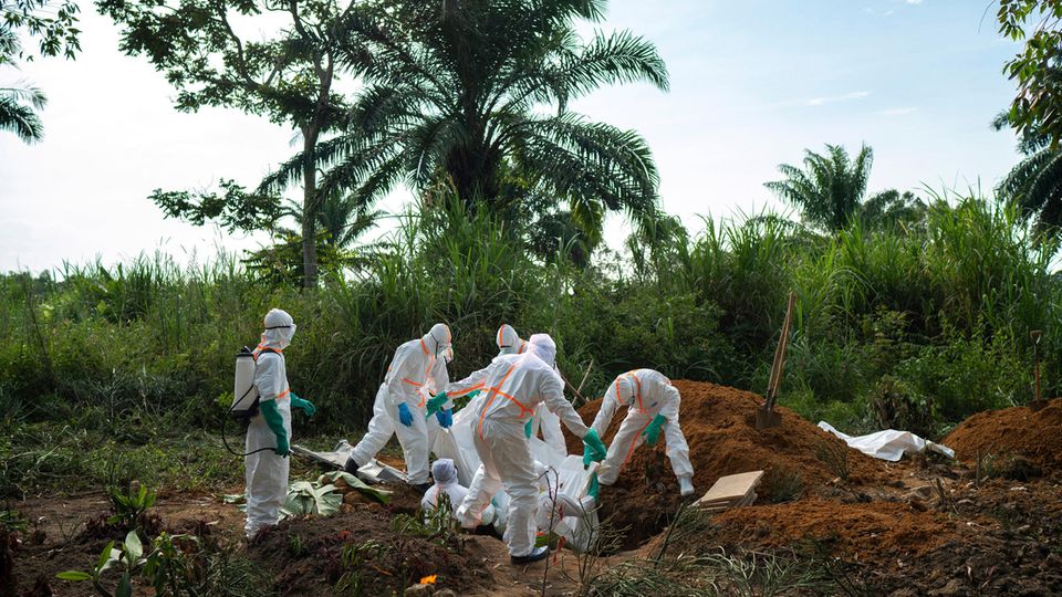 Helfer tragen in der Demokratischen Republik Kongo den Leichnam eines an Ebola gestorbenen Mannes zu Grabe.