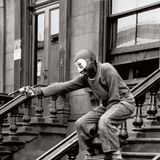 Ein maskierter Junge steht auf der Treppe eines Hauseingangs