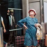 Zwei alte Damen mit Koffern am Straßenrand