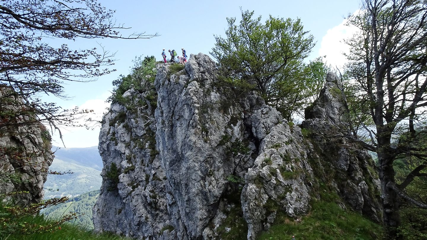Kletterer haben es gerade auf einen der Kalkgipfel geschafft. Hier ist das südlichste Klettergebiet der Schweiz. Es gibt Routen zwischen dem 3. und 8. Schwierigkeitsgrad.