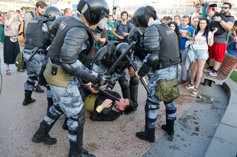 In Moskau liegt ein Mann am Boden, um ihn herum stehen Polizisten