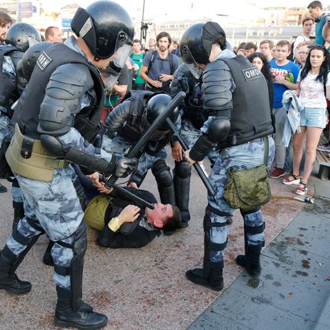 In Moskau liegt ein Mann am Boden, um ihn herum stehen Polizisten