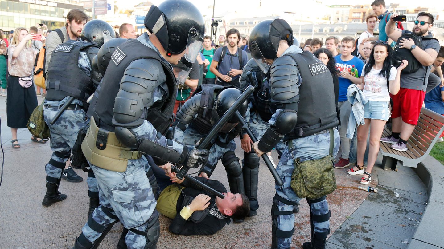 In Moskau liegt ein Mann am Boden, um ihn herum stehen Polizisten