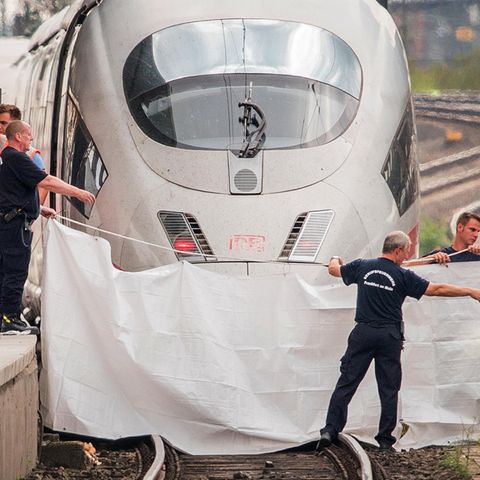Einsatzkräfte spannen nach der Tat im Frankfurter Hauptbahnhof eine weiße Plane als Sichtschutz vor den ICE