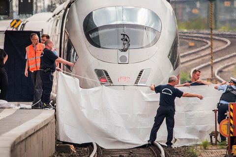 Einsatzkräfte spannen nach der Tat im Frankfurter Hauptbahnhof eine weiße Plane als Sichtschutz vor den ICE