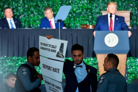 US-Präsident Donald Trump (im Hintergrund) unterbrach seine Ansprache, während der Abgeordnete Ibraheem Samirah (M.) aus dem Saal gebracht wurde