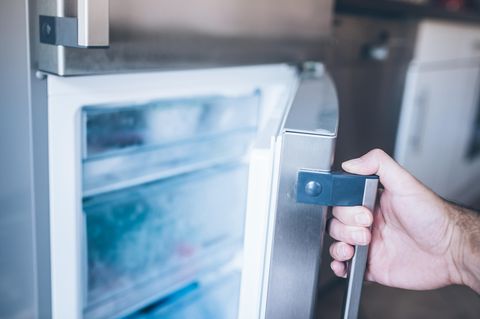 Eine Männerhand öffnet eine Tiefkühltruhe