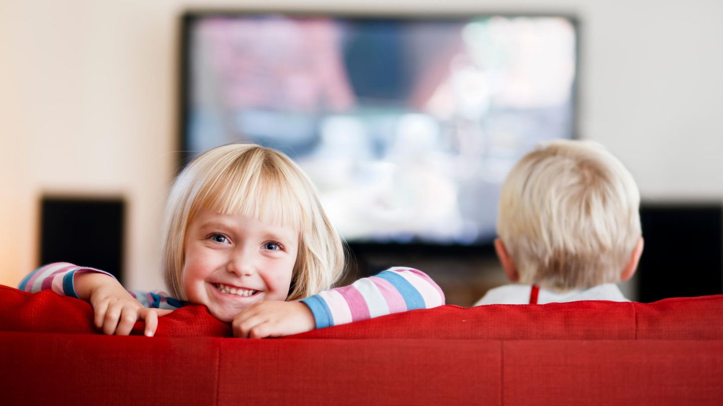 Kind grinst auf dem Sofa