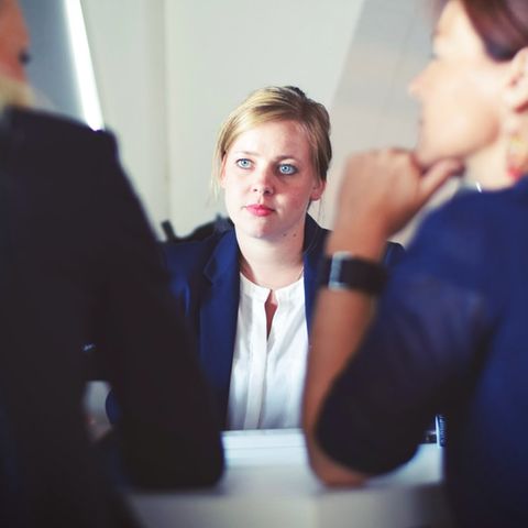 Frau sitzt im Vorstellungsgespräch gegenüber von zwei anderen Frauen