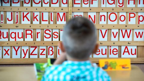 Ein Grundschüler vor einer Buchstabentafel. Für manche Migrantenkinder ist die erste Klasse der erste intensive Kontakt mit der deutschen Sprache