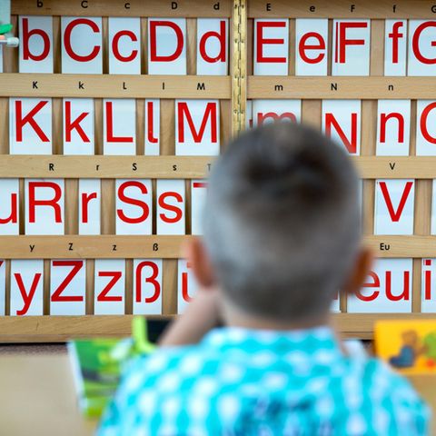 Ein Grundschüler vor einer Buchstabentafel. Für manche Migrantenkinder ist die erste Klasse der erste intensive Kontakt mit der deutschen Sprache