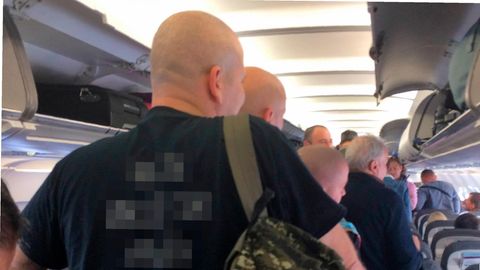 Kräftige, kahl rasierte Männer im Flugzeug