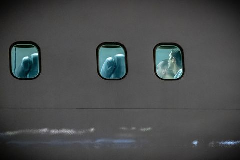 Blick von außen auf ein Flugzeug, hinter den Scheiben sind Menschen zu sehen