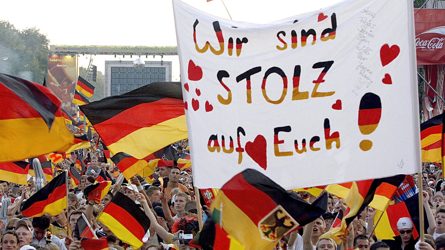 Deutsche Fans mit Fahnen jubeln auf einem Fanfest bei der Fußball-WM 2006