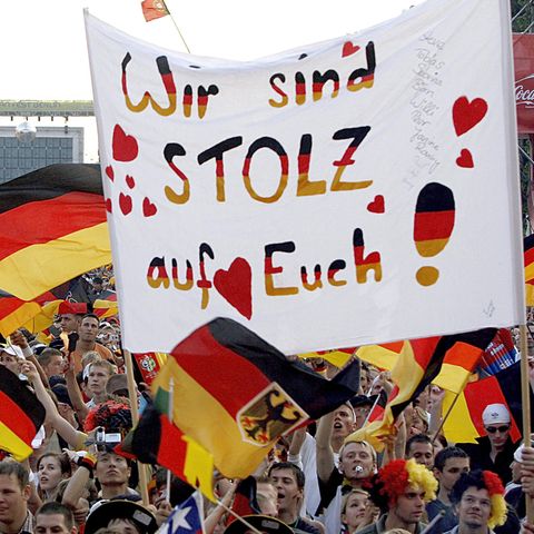 Deutsche Fans mit Fahnen jubeln auf einem Fanfest bei der Fußball-WM 2006