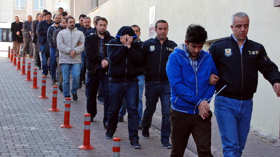 Türkische Polizisten führen verhaftetete Männer ab