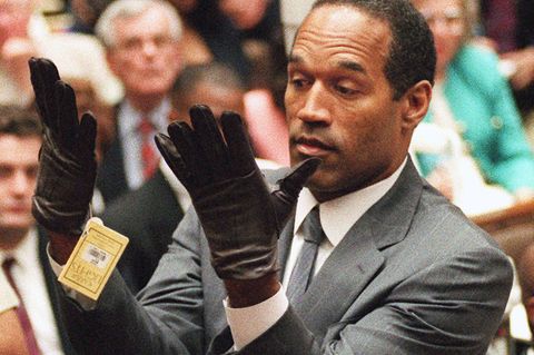 O. J. Simpson schaut verwundert auf zwei schwarze Handschuhe
